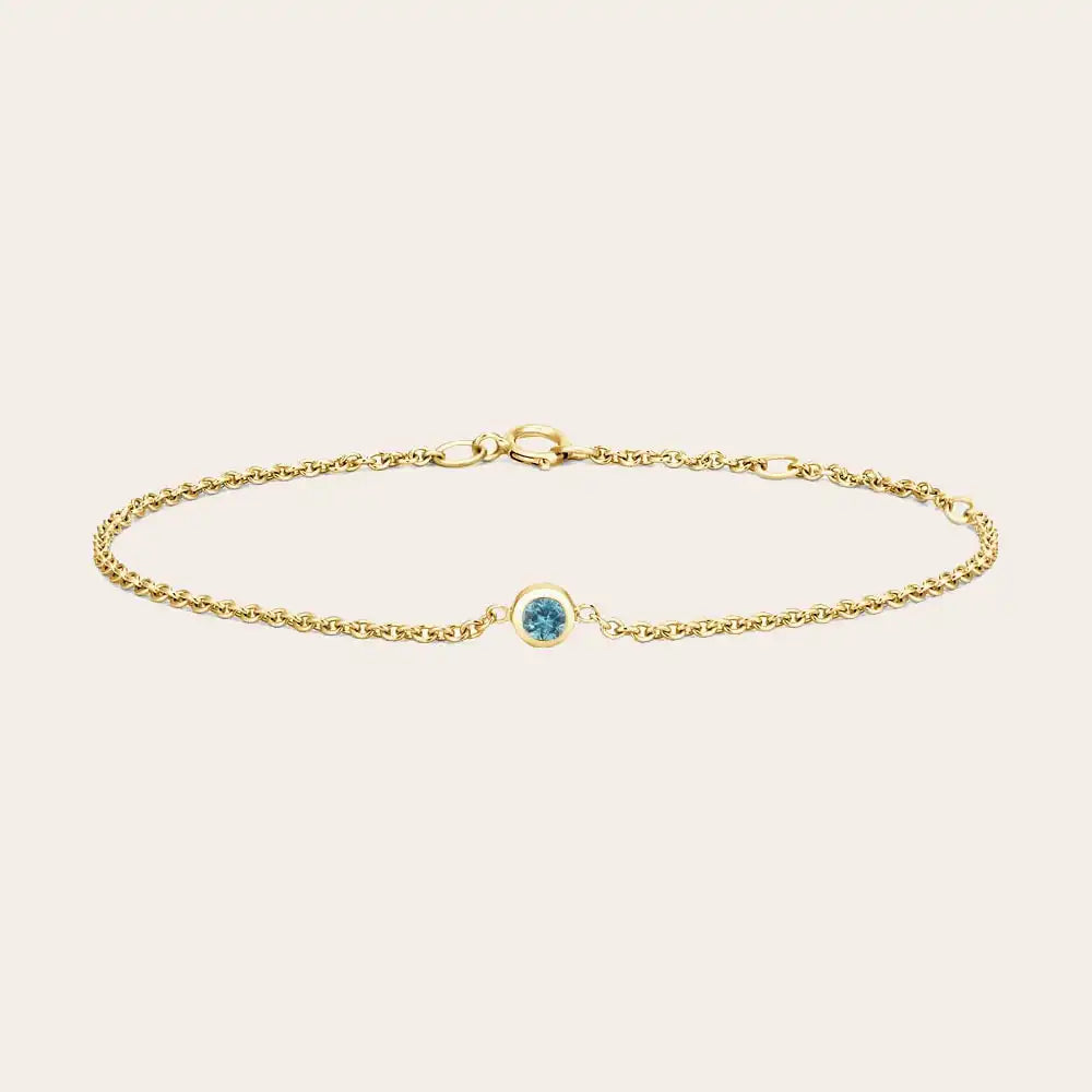 Bezel-set zircon bracelet flatlay blue variation in daylight yellow gold variant--14K-yellow-gold variant--Zircon