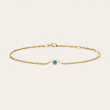Bezel-set zircon bracelet flatlay blue variation in daylight yellow gold variant--14K-yellow-gold variant--Zircon