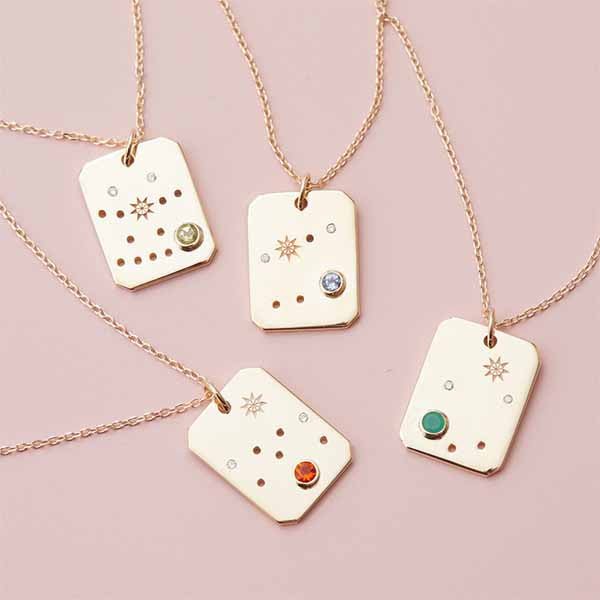 Zodiac pendants in gold with birthstones and diamond constellation styled layed flat