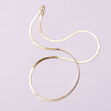 14k gold herringbone chain styled casually for everyday wear.