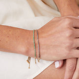 Adjustable tennis bracelet in 14K gold worn on wrist
