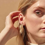 Meaningful diamond stud earrings angel wings shown on model