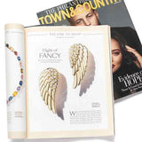 Gold angel wings earrings shown in town and country magazine