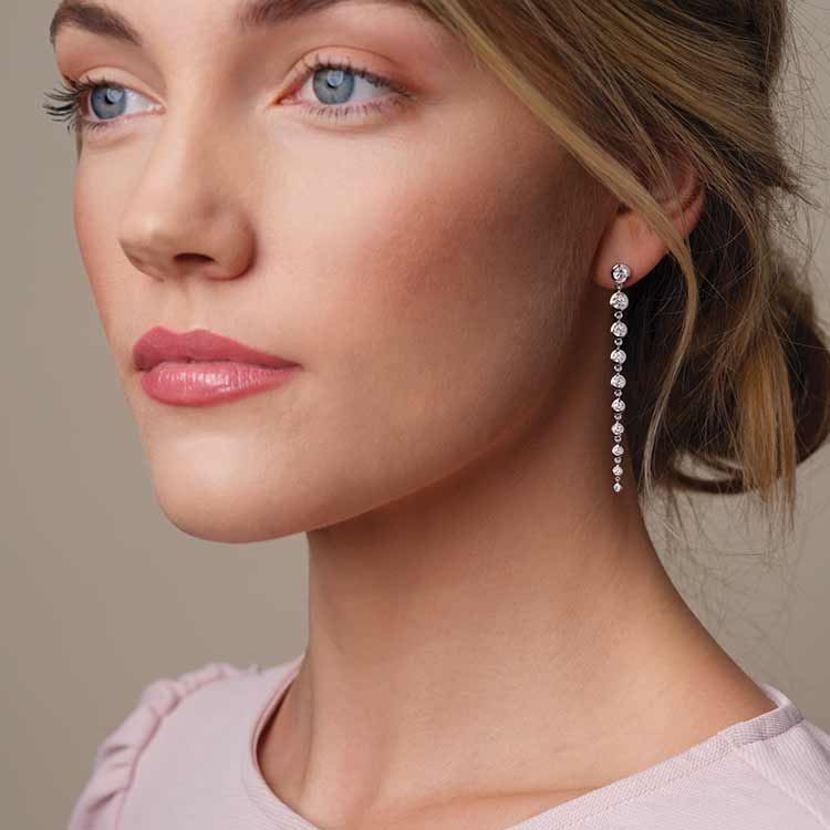 Lab-created diamond chandelier earrings in solid gold shown on model