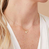 Diamond compass charm with four diamond accents shown on model