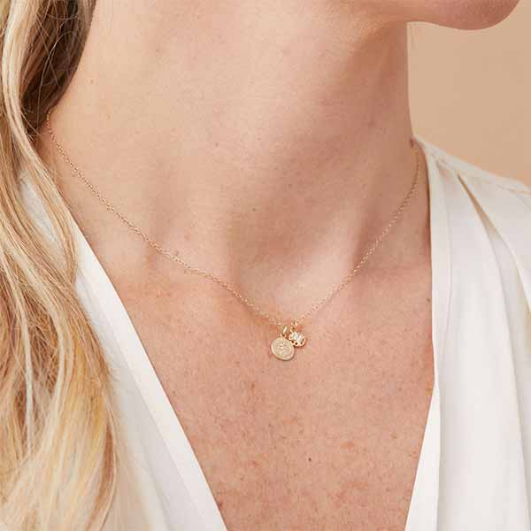 Diamond compass charm with four diamond accents shown on model