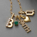 Diamond faith charm in 14K gold with subtle diamond accents layered with other charms