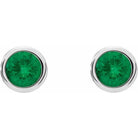 Close-up of emerald stud earrings in 14K white gold on white background