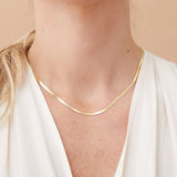 14k gold herringbone necklace styled as a statement piece with white blouse.