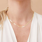14k gold herringbone necklace styled as a statement piece with white blouse.