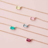 Emerald-cut birthstone necklace on 18-inch gold cable chain, editorial styling