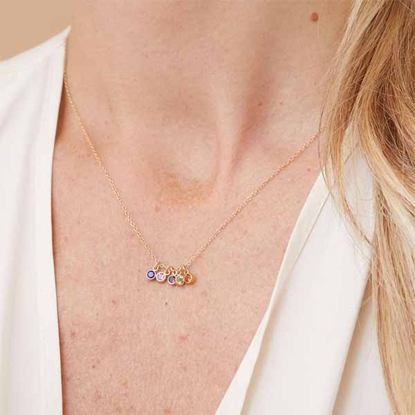 Model wearing 14k gold bezel-set birthstone charms on a necklace — personalized, meaningful jewelry.