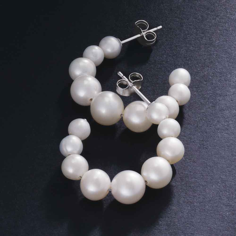 Side view of sterling silver pearl hoop earrings.